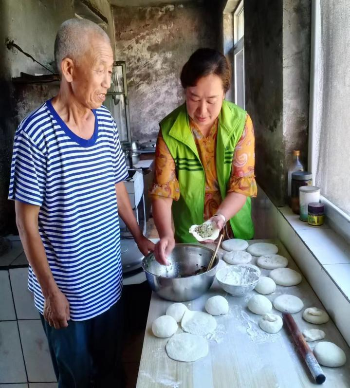 图四 政府购买居家养老服务的服务人员为老年人制作老年餐.png