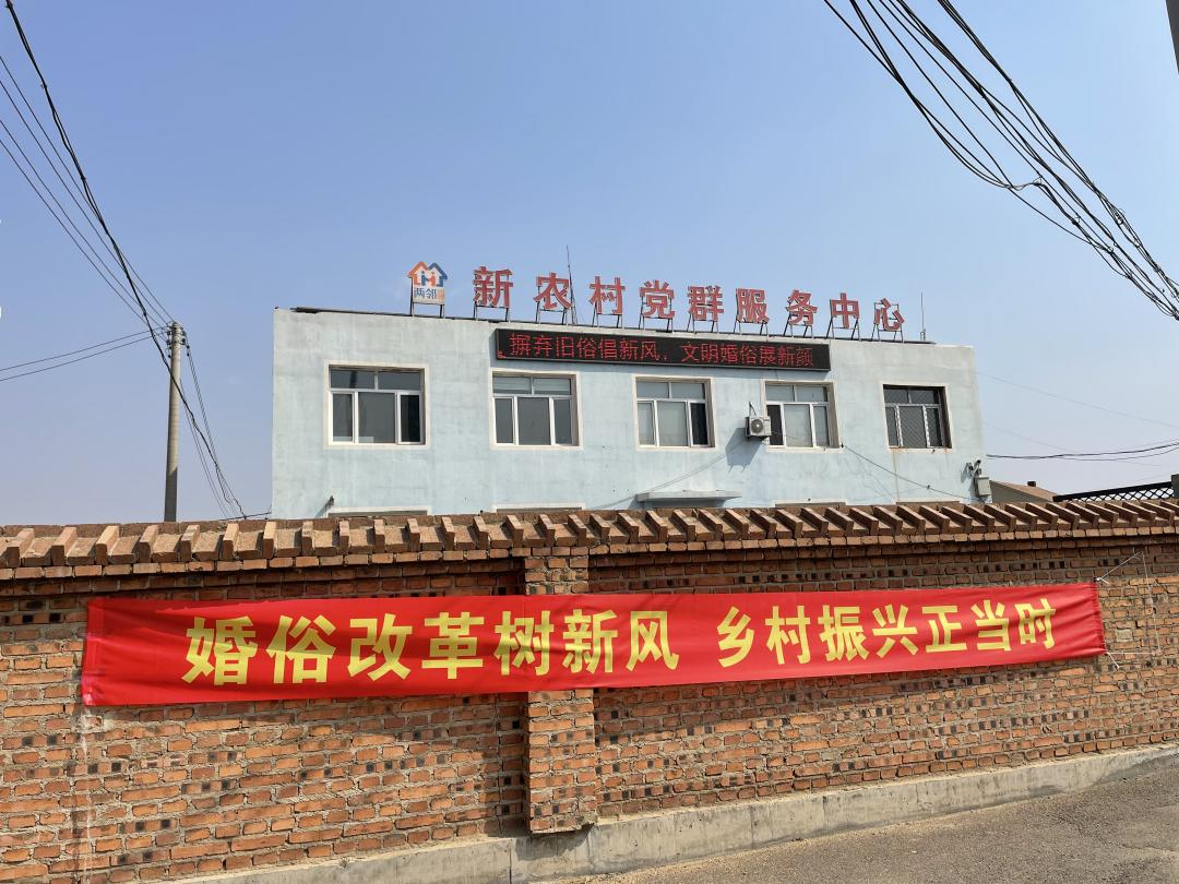 图四:新农村党群服务中心门前悬挂婚俗改革宣传横幅.png